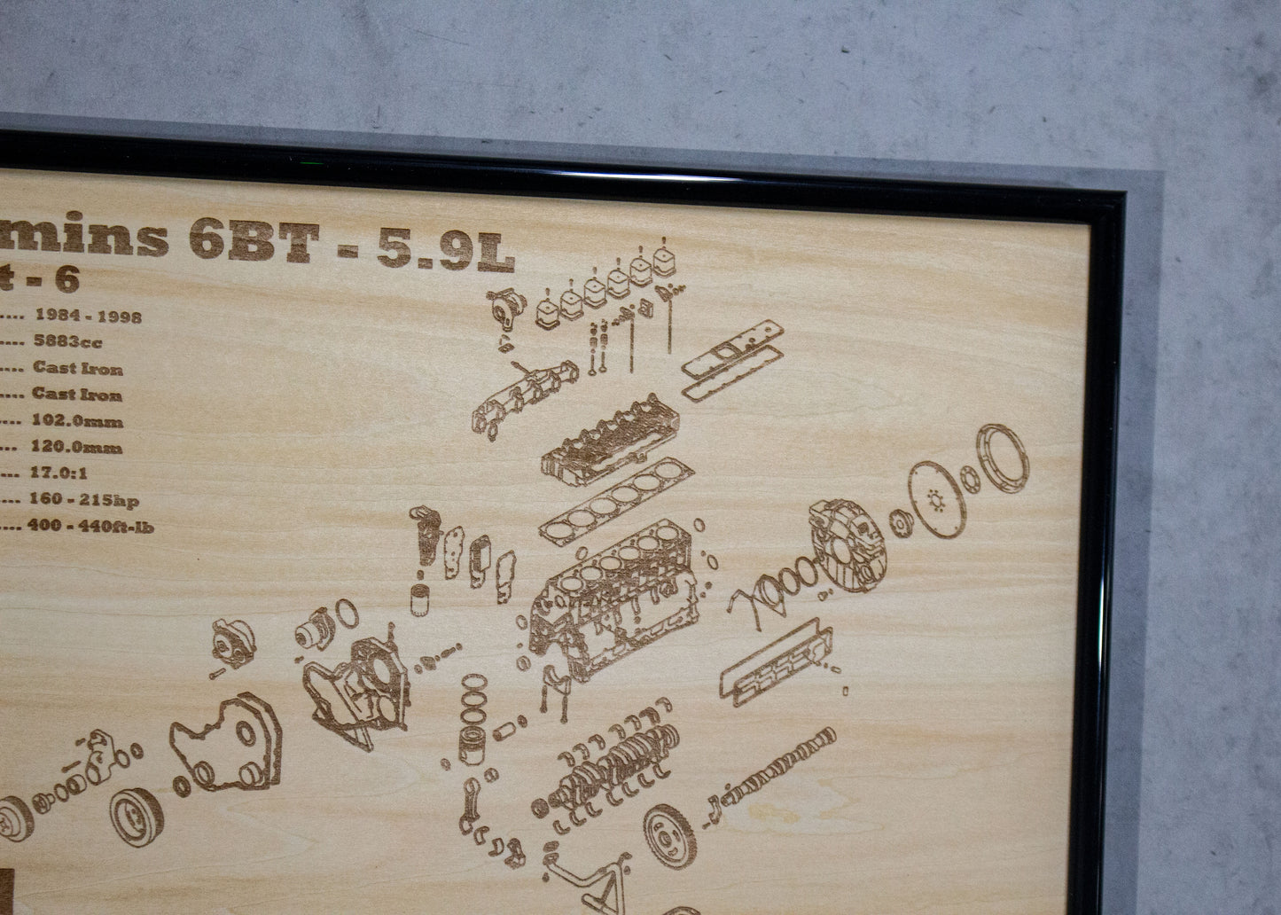 Wooden plaque with laser-engraved diagram of a diesel engine on a gray background